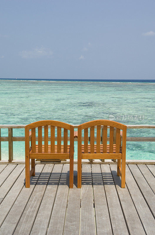 椅子在海滩附近的甲板上