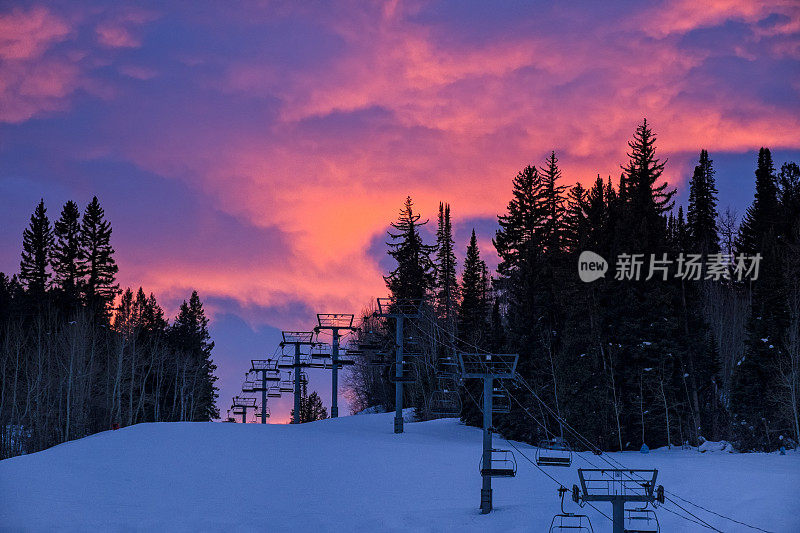 滑雪跑道的剪影在日落与戏剧性的粉红色云彩