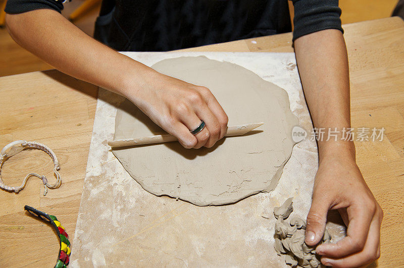 年轻女子在木桌上做粘土