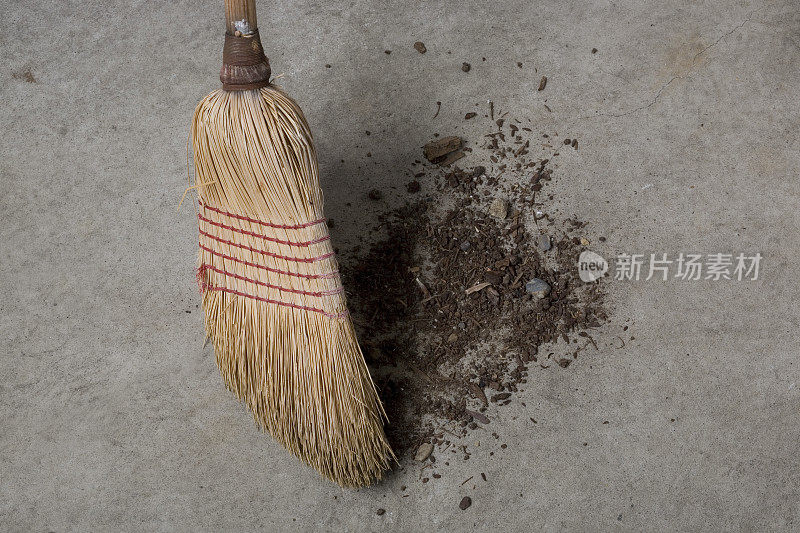 特写的旧稻草扫帚扫灰尘。