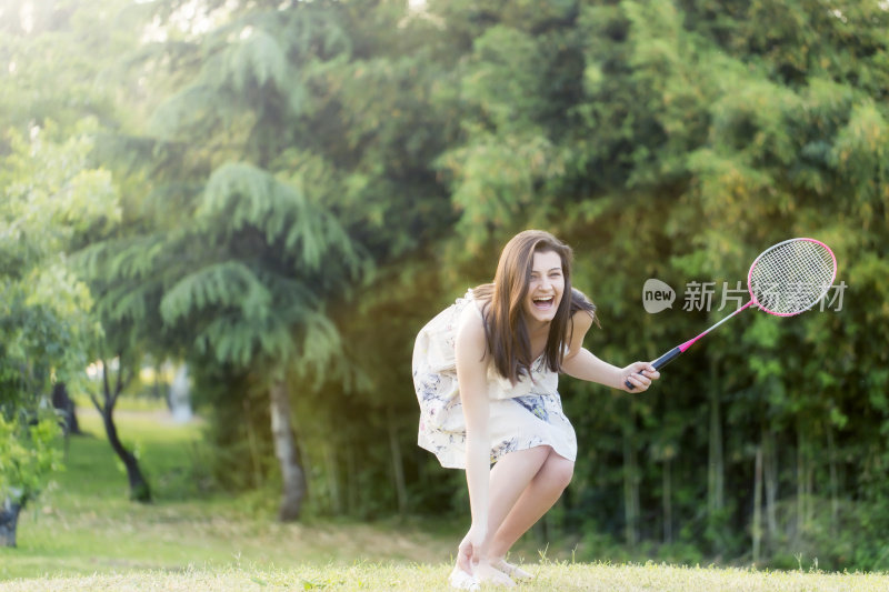 女子打羽毛球对夏季城市公园。