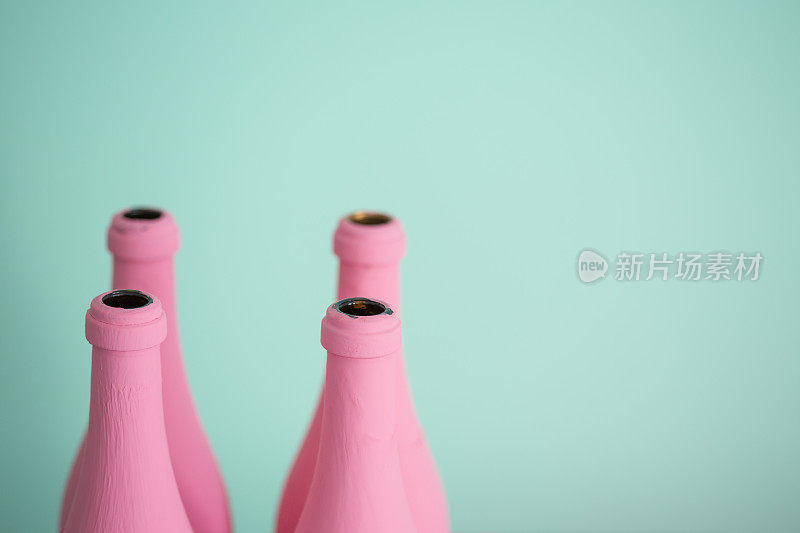 粉红色的瓶子映衬着柔和的绿松石色背景