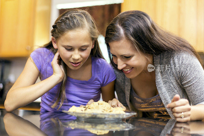 母亲和女儿看着自己做的饼干