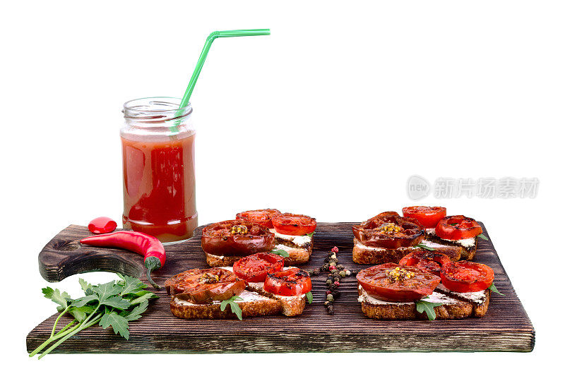 切菜板上放着三明治和烤番茄。用吸管装在杯子里的番茄汁。