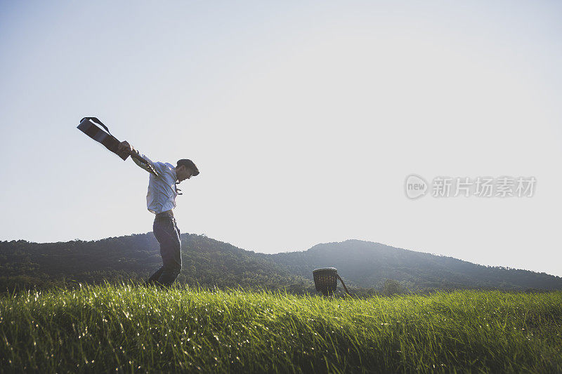 年轻有权势的男人拿着吉他在球场上跳来跳去