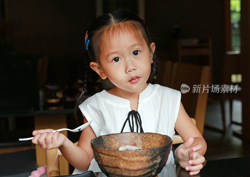 亚洲小女孩吃米饭美味的日本食物在餐桌上的午餐在餐厅。