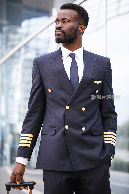 一个黑人飞行员在机场散步