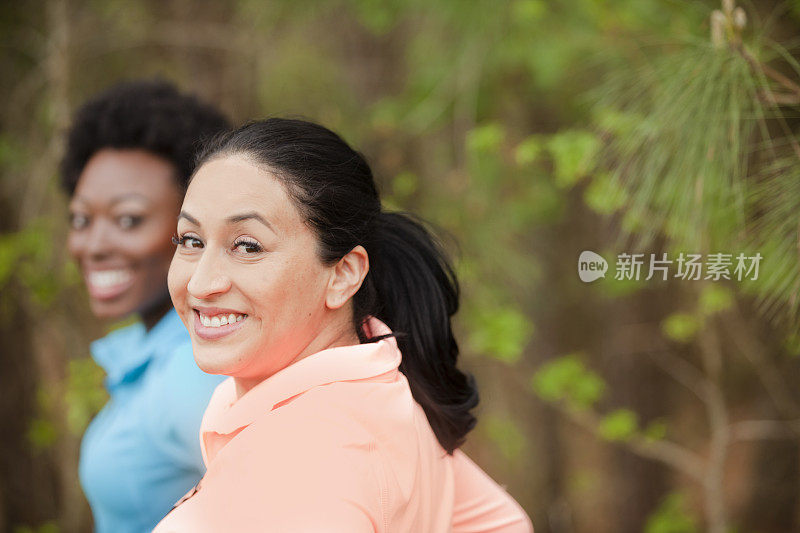 两个女性朋友在附近的公园里跑步。