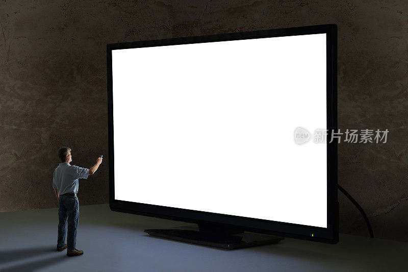 一名男子将电视遥控器指向世界上最大的黑屏巨型电视机