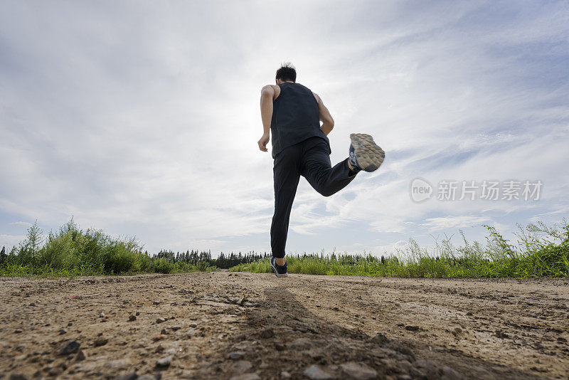 跑步者迎着乌云在土路上奔跑