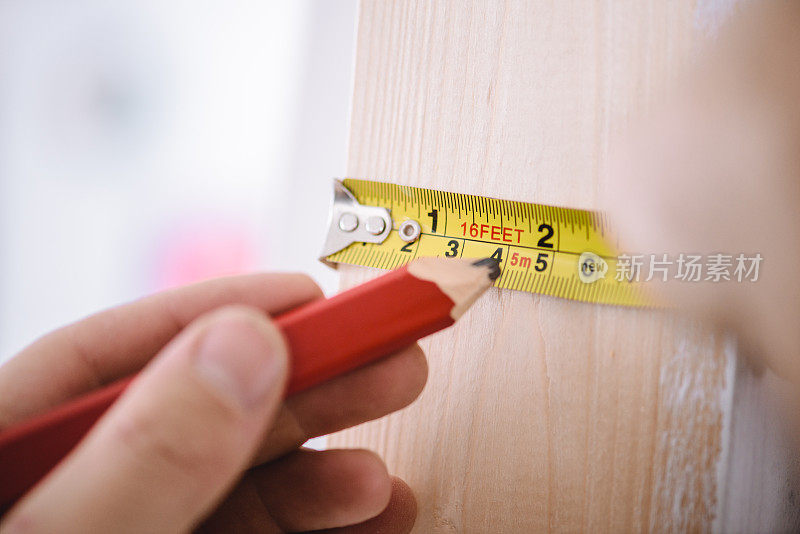 人用木工笔和卷尺测量家丈量改善近