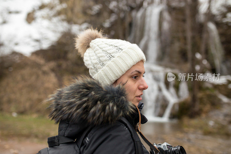 女徒步旅行者看着瀑布。