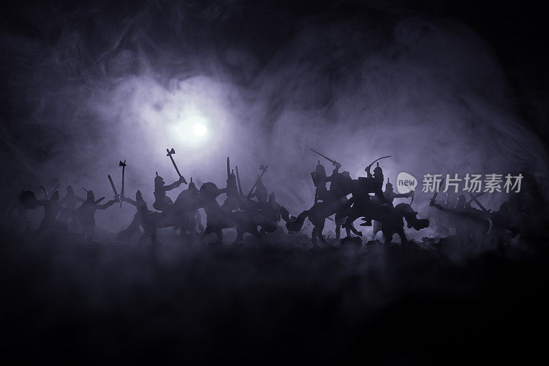 有骑兵和步兵的中世纪战斗场景。剪影的人物作为单独的对象，战斗的战士之间的黑暗色调的雾背景。夜景。