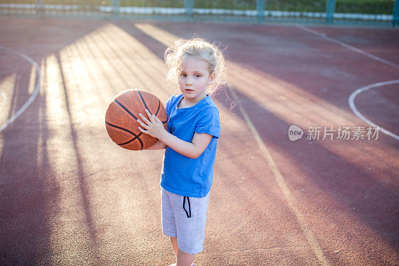 小女孩在球场上玩篮球