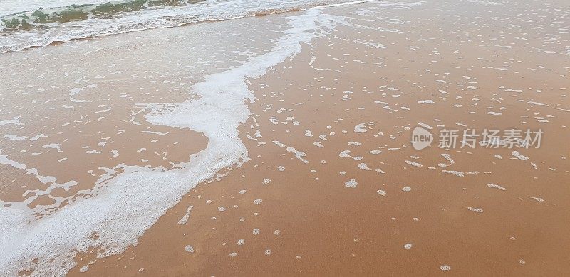 泡沫状的白色海浪拍打着海滩