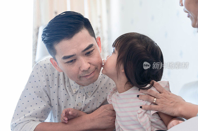 一个中国女孩在吻她的父亲