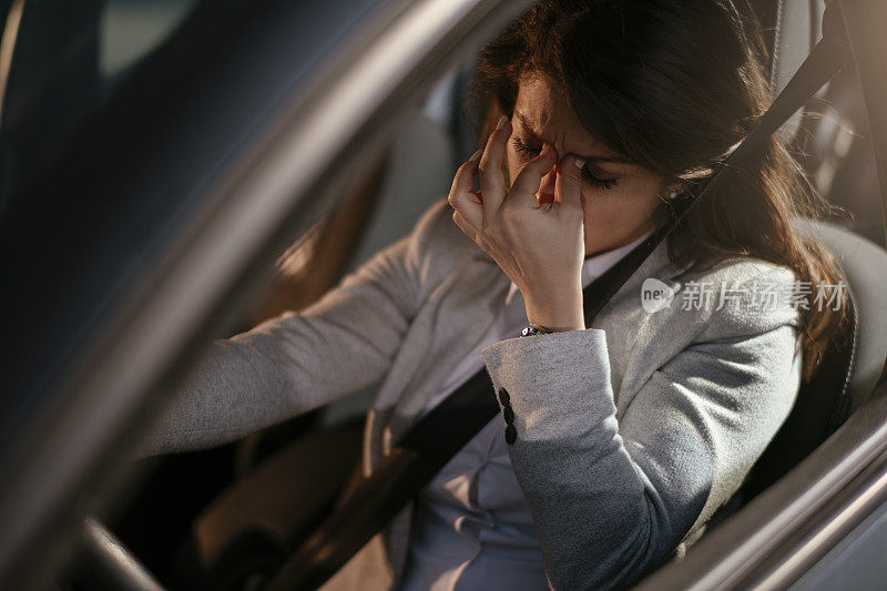 女商人开车累了昏昏欲睡的女商人开着她的车