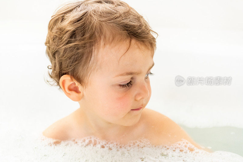 一个三岁的男孩在浴缸里