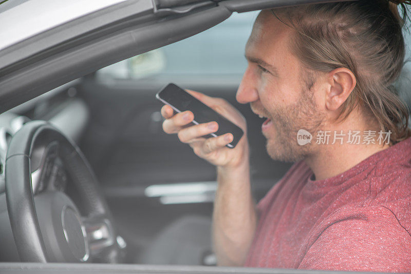 快乐的年轻人坐在车里用智能手机打电话