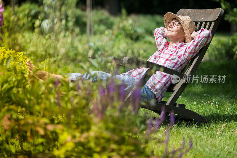 园艺-年长妇女在甲板上享受放松在花园户外