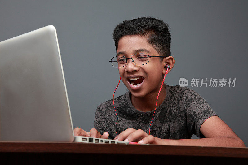 一个小男孩在用笔记本电脑