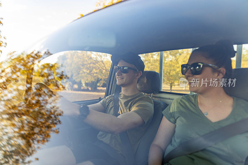 一对年轻夫妇在农场的土路上开车