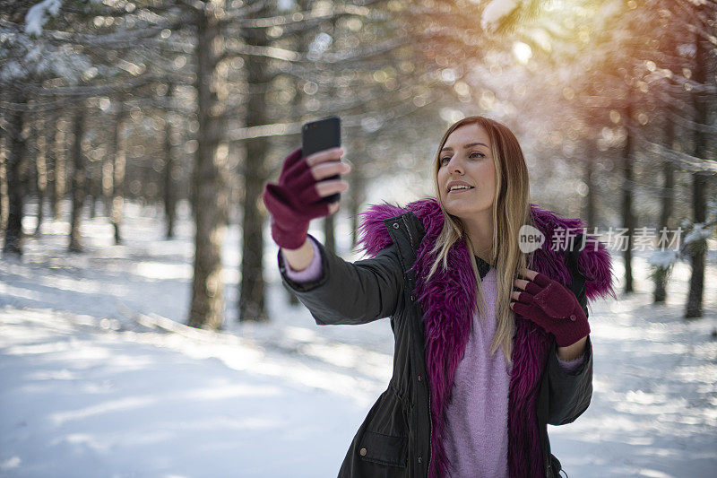 可爱的女人在雪域森林里自拍