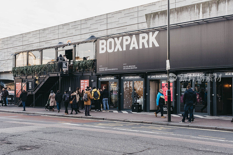 人们走过英国伦敦肖尔迪奇区BOXPARK购物中心的商店。