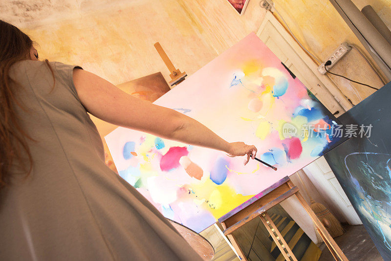 年轻女子画家在她的画室油画