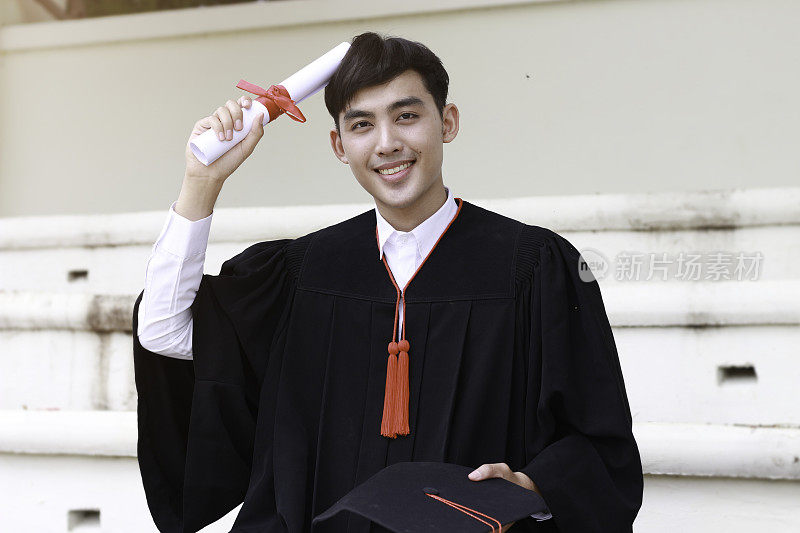 快乐毕业的学生手拿黑帽和证书完成大学学业，概念毕业日