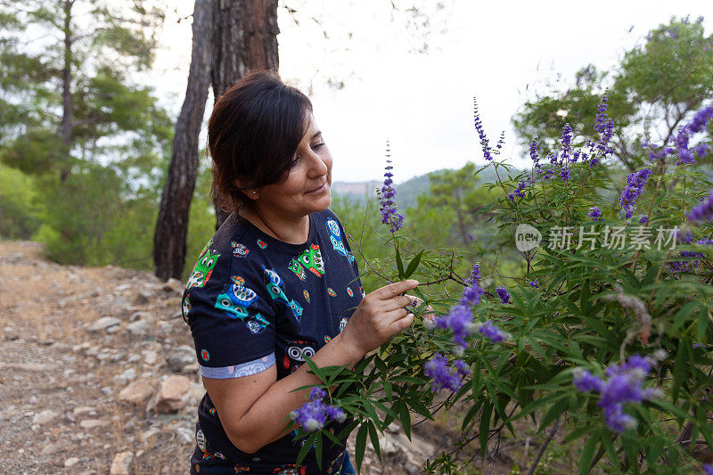 年轻的成年女子闻着植物的花