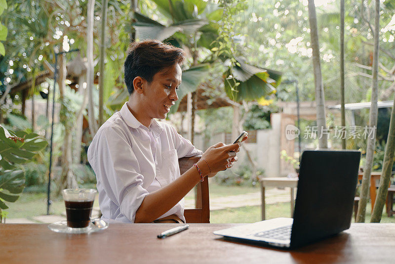 年轻的印尼男性正在看智能手机
