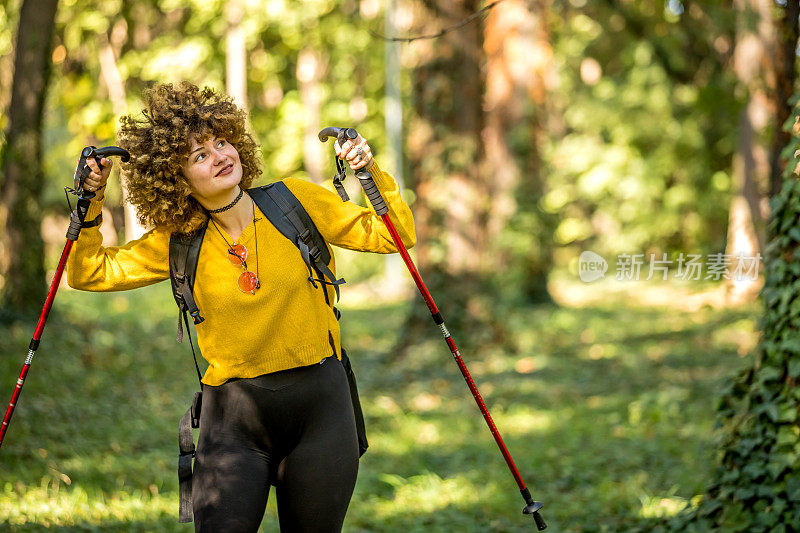 拿着登山手杖的年轻女子在山顶