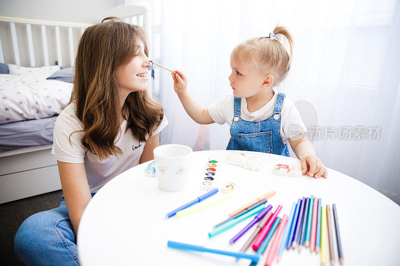 妈妈和女儿一起画画。那孩子和他母亲一起画画。
