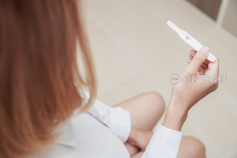 妇女手握医学排卵试验阳性妊娠结果。
