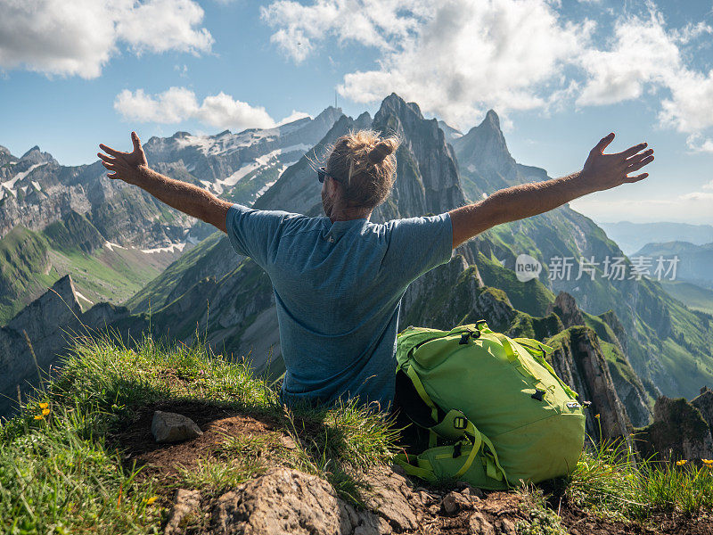山顶上的人张开双臂拥抱自由和自然