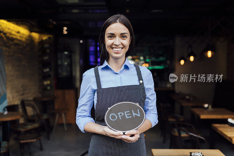 一个快乐的年轻白种女服务员重新开张的肖像