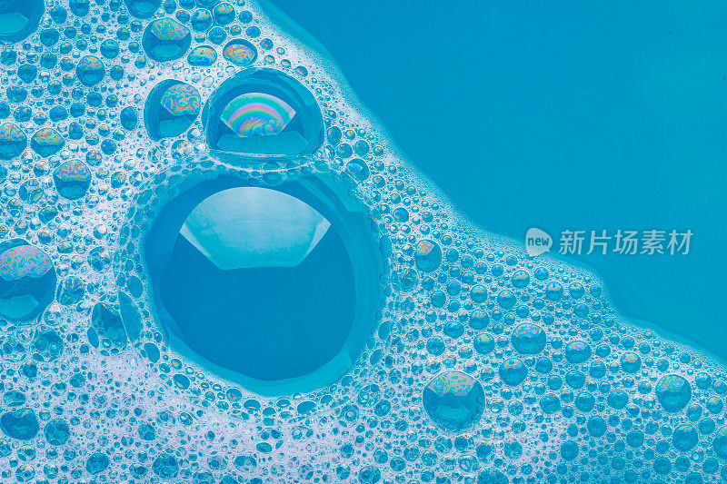 肥皂在蓝色的水中产生泡沫