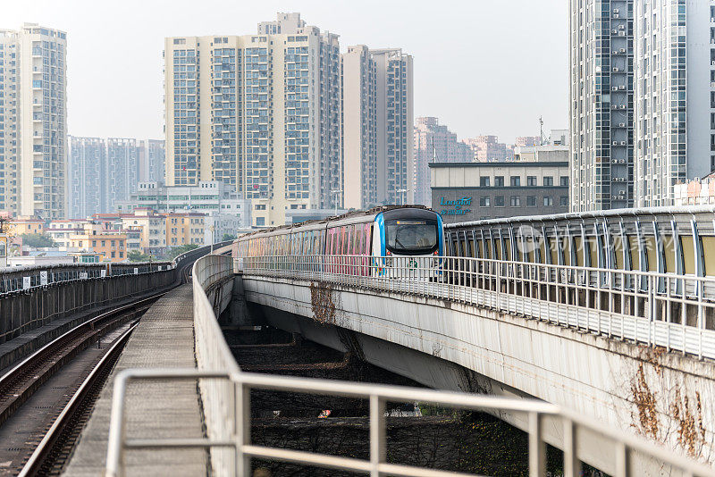 深圳地铁列车在轨道上运行，背景是中国深圳的天际线。