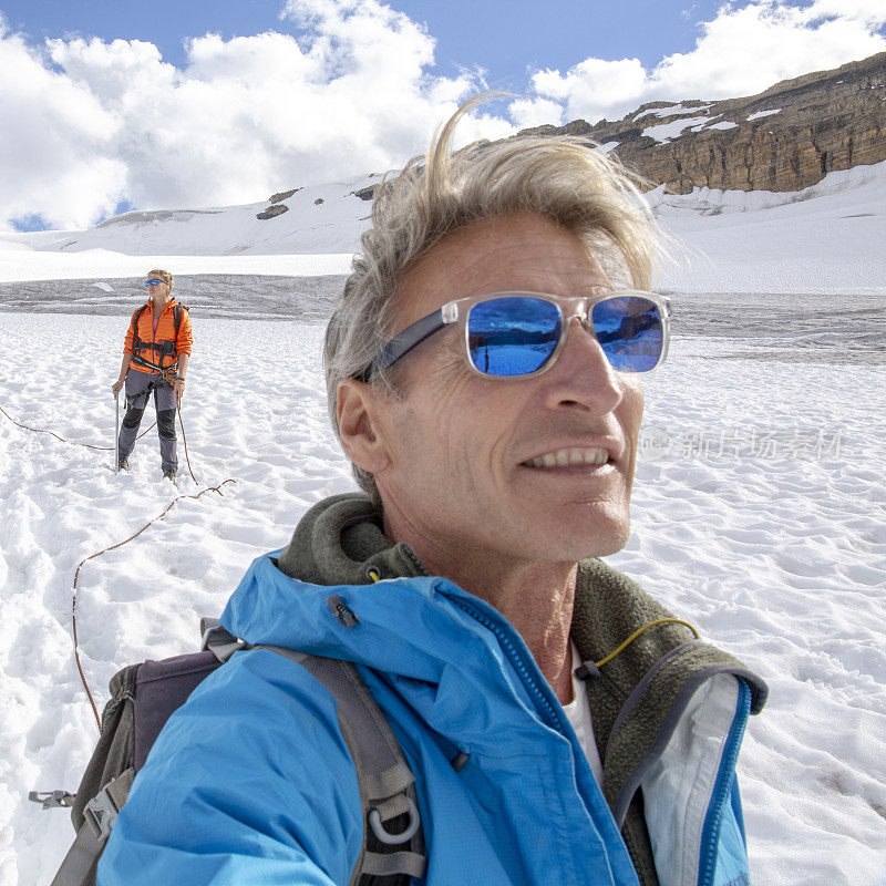 一位男性登山运动员到达了雪山的顶峰