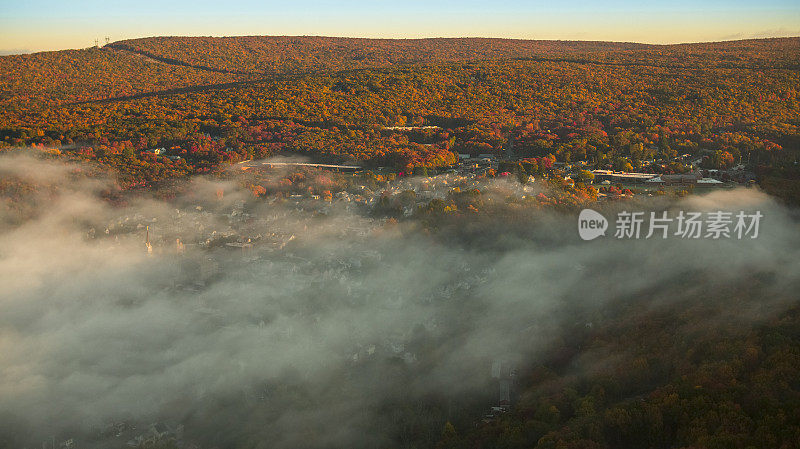 五彩缤纷的秋日里，波科诺山脉的清晨阳光明媚，历史小镇吉姆·索普上空云层低垂。宾夕法尼亚州,碳县。
