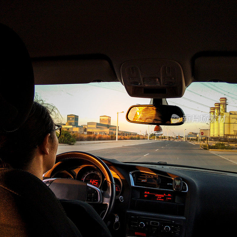 一位职业妇女在日落时分开车上班