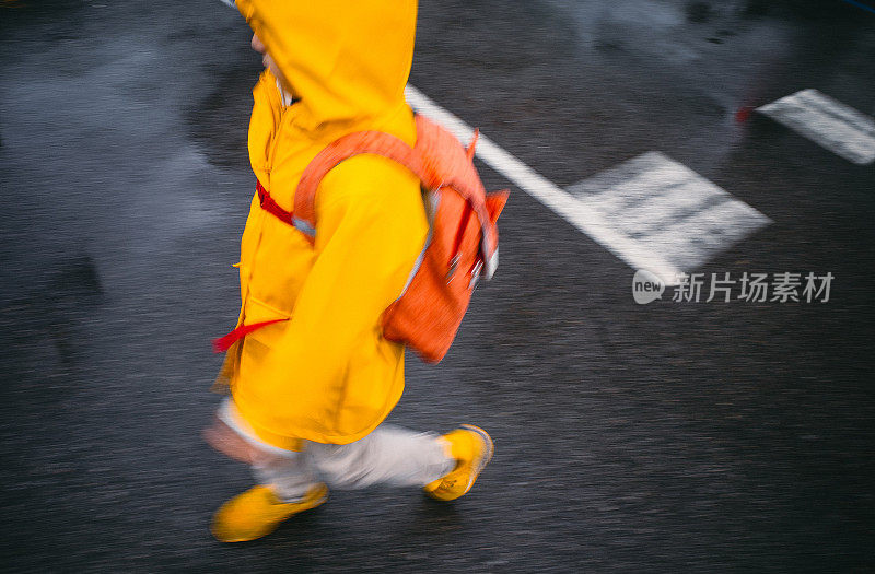 孩子在雨中行走，动作模糊