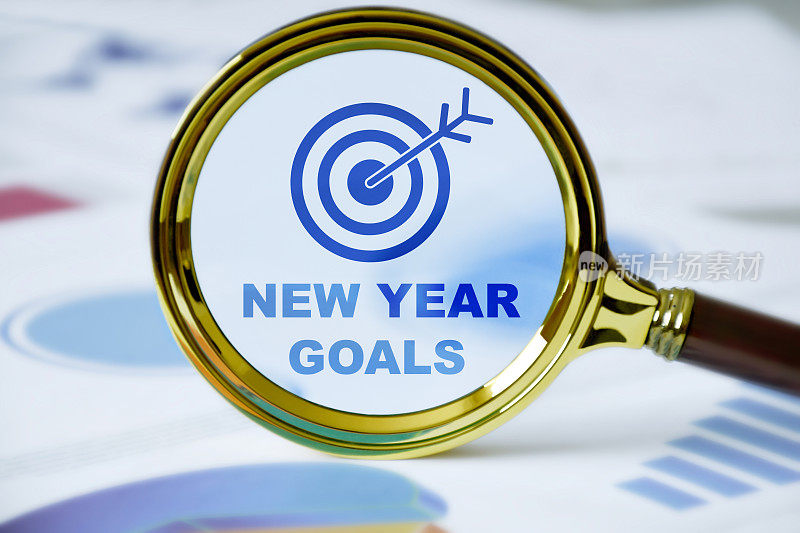 新的一年的目标。业务目标图标和新年目标在放大镜与业务图形