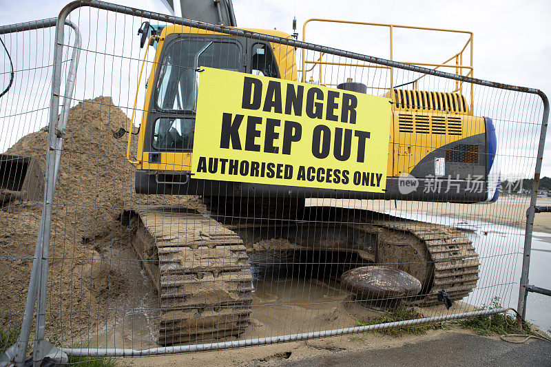 挖掘机前的金属围栏上有“禁止入内”的标志