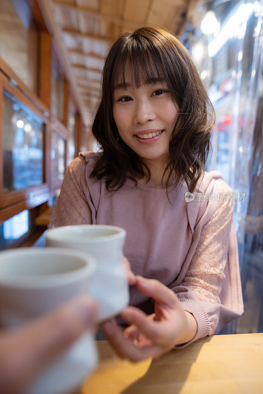 女子在户外餐厅喝着一杯日本茶