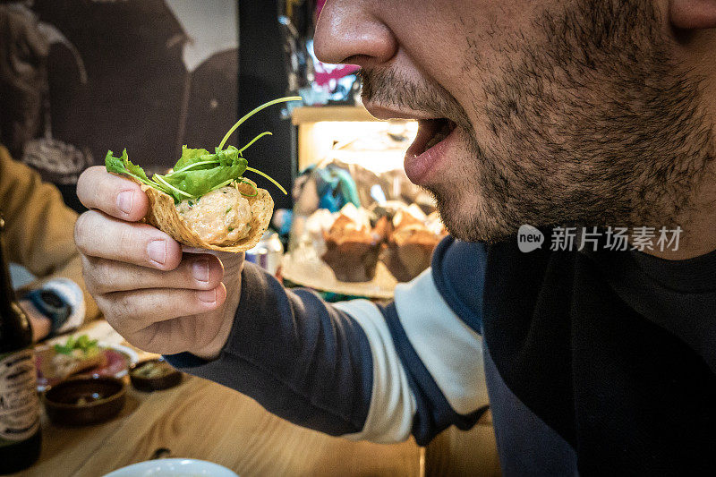 大胡子男子在城里的西班牙高级餐厅吃小吃。