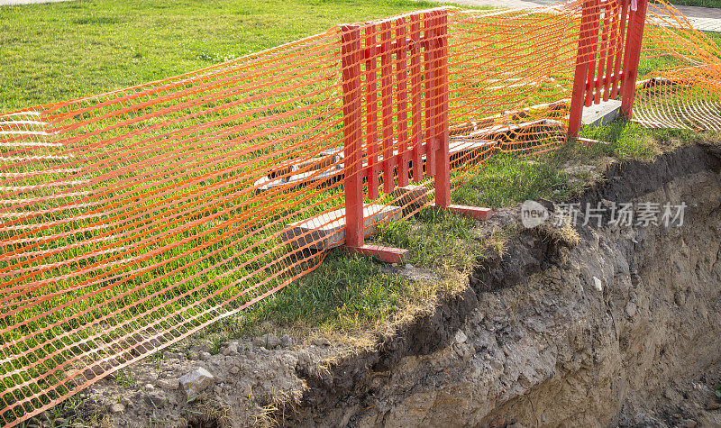 地下公用设施维修时在沟边设置防护围栏。特写,夏天,户外