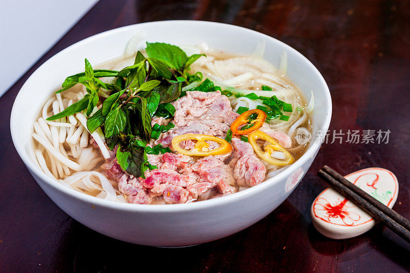 越南河粉汤，牛肉和米粉放在桌子上，特写。越南当地的餐馆。