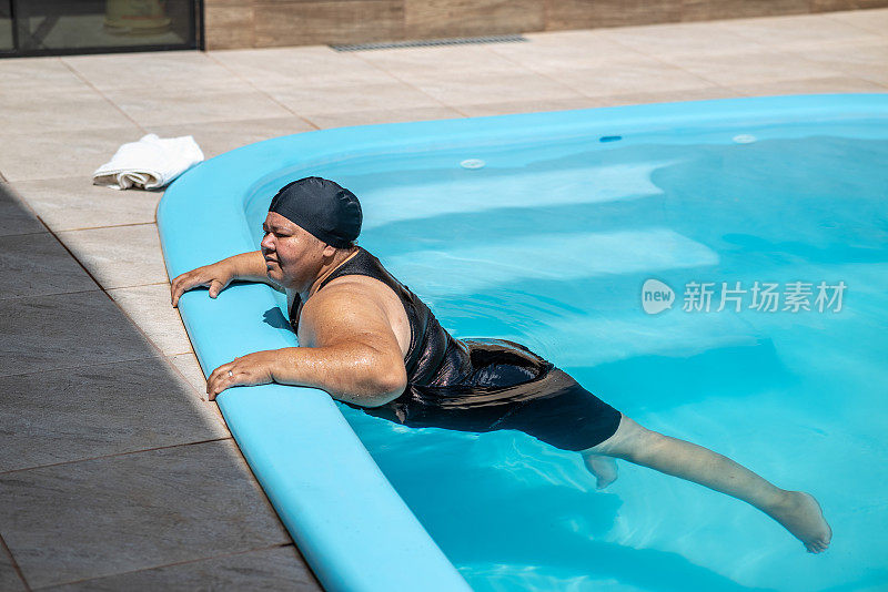 在阳光明媚的日子里，一位拉丁妇女在泳池边锻炼